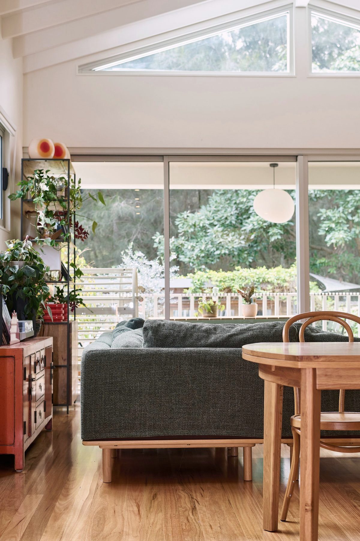 Living space with a high gable window and garden view